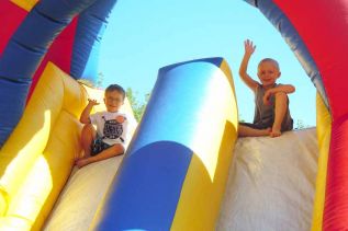 l-r Ethan Consack of Sydenham and Skylar Hickey of Verona enjoyed a high ride on the bouncy slide at the Harrowsmith Free Methodist church's annual Community Fun Day event on May 31